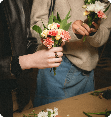 Deux personnes tenant de petits bouquets de fleurs fraîches lors d'un atelier floral.
